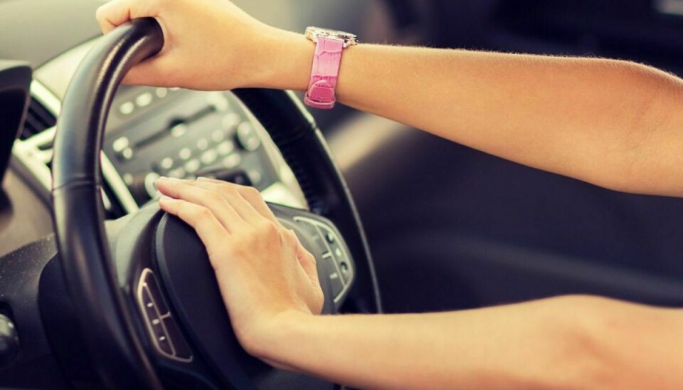 transportation and vehicle concept – woman driving a car with hand on horn button