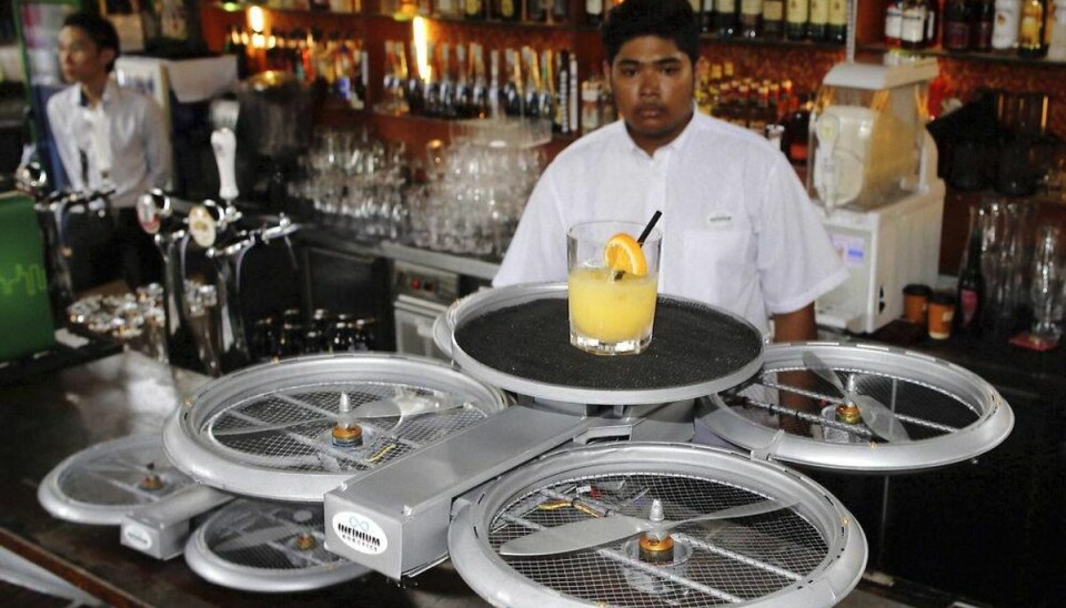 Tjenere kan måske bliove erstattet af droner, der bringer bestillingen til gæsterne. Her testes en tjener-drone på en bar i Singapore. Foto: Edgar Su/Scanpix