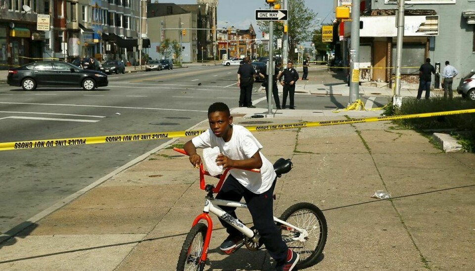 A young boy, who lives in the neighborhood where Freddie Gray was arrested and where residents rioted over his death in April, is stopped by police tape at the scene of a shooting where two men were shot at the intersection of West North Avenue and Druid Hill Avenue in West Baltimore, Maryland May 30, 2015. Local media have reported 40 murders in the city of Baltimore since the April rioting over the death of 25-year-old resident Freddie Gray and shootings continue regularly in his West Baltimore neighborhood. REUTERS/Jim Bourg