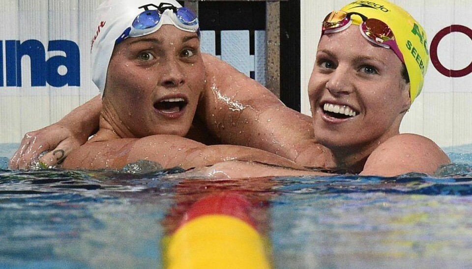 Australia’s Emily Seebohm (R) reacts next to Denmark’s Mie Oe Nielsen at the end of a semi-final of the women’s 100m backstroke swimming event at the 2015 FINA World Championships in Kazan on August 3, 2015. AFP PHOTO / MARTIN BUREAU