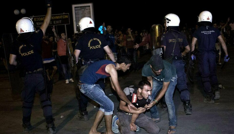 Der var voldsomme sammenstød mellem migranter og græske politibetjente, da en gruppe migranter prøvede at storme om bord på en færge fra øen Lesbos lørdag aften. Foto: ANGELOS TZORTZINIS/Scanpix
