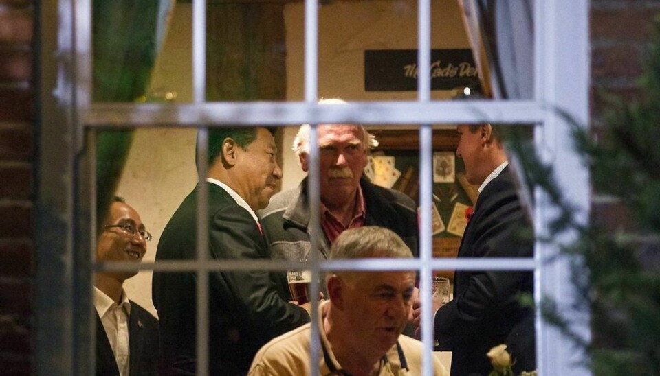 Kinas præsident (tv.) og den engelske premierminister (th.) fik sig en hyggesnak på en engelsk traditionel pub. Foto: Eddie Keogh/Scanpix