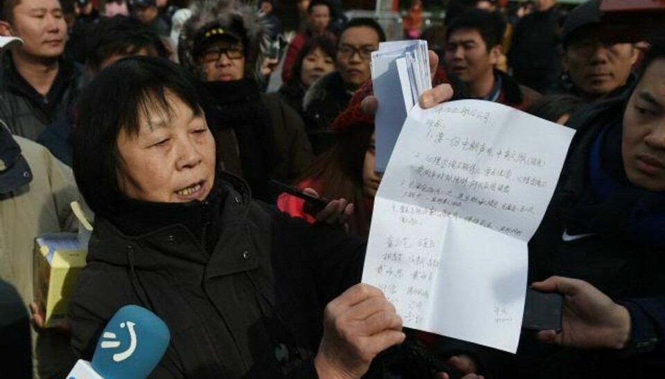 En kinesisk kvinde og pårørende til en af de forsvundne fra flyet. Billedet er taget til en ceremoni, der markerer toårsdagen for MH370’s forsvinden. Foto: Greg Baker/AFP