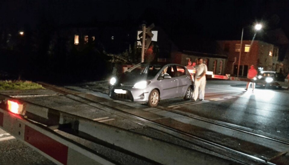 Et norsk ægtepar er fanget på skinnerne mellem bommene. Imens nærmer toget sig. Foto: Elinilda Gliemann. Et norsk ægtepar er fanget på skinnerne mellem bommene. Imens nærmer toget sig. Foto: Elinilda Gliemann.