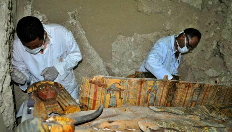 Eksperter er i gang med at undersøge de sarkofager med mumier og skulpturer, der blev fundet i en grav uden for Luxor. Graven menes at være 3500 år gammel. Foto: Stringer/AFP