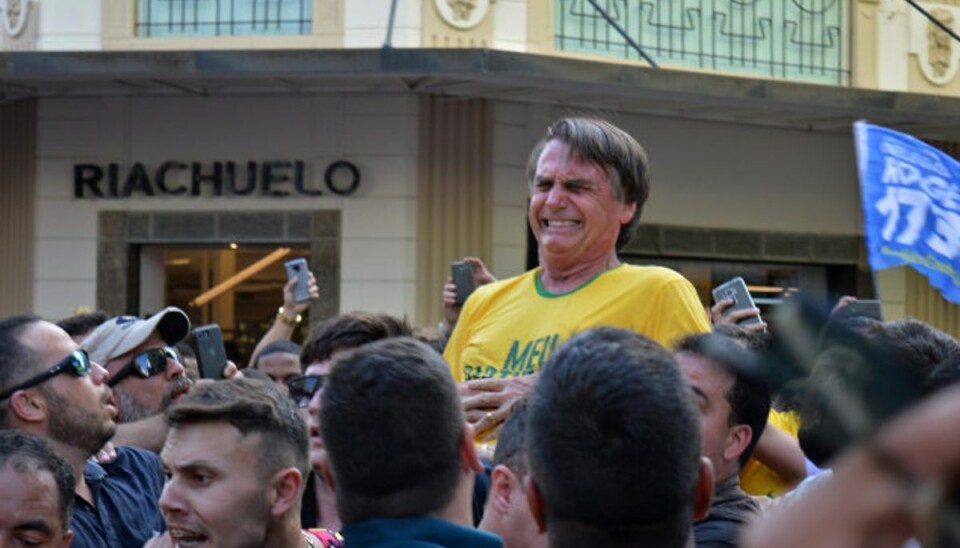 Præsident falder og må på hospitalet Jair Bolsonaro red på skuldrene af politiske støtter, da han pludselig skreg af smerte efter at være blevet stukket med en kniv i maven i begyndelsen af september sidste år. Foto: Raysa Leite/AFP