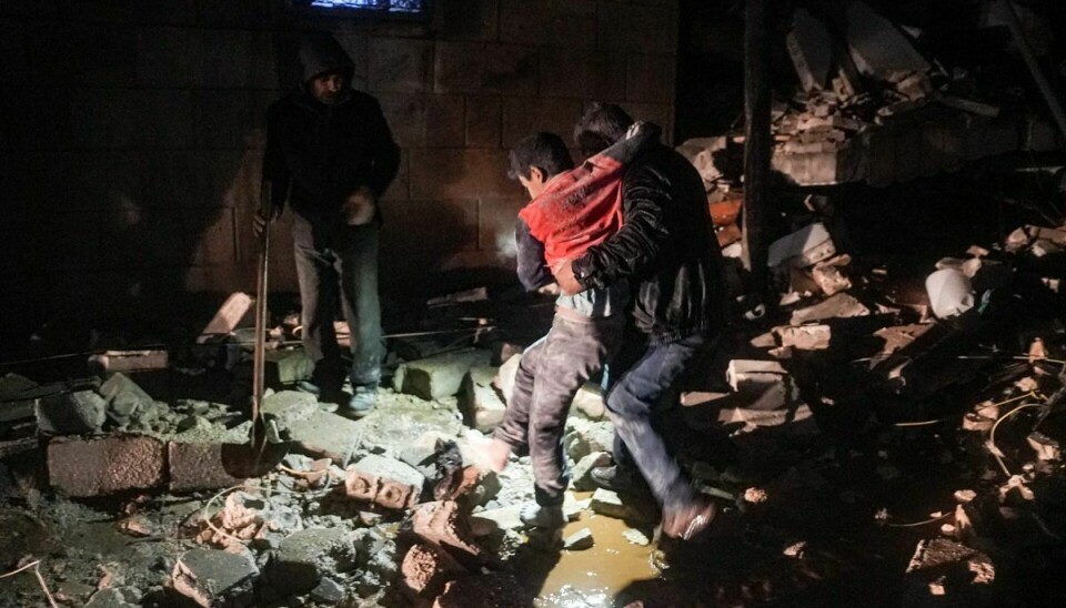 Et barn reddes ud af en sammenstyrtet bygning i Syrien.