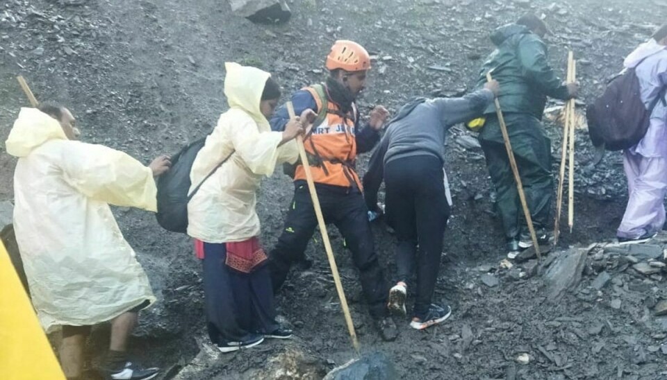 Redningsfolk hjælper med at få folk til mere sikre områder nær Amarnath-hulen.