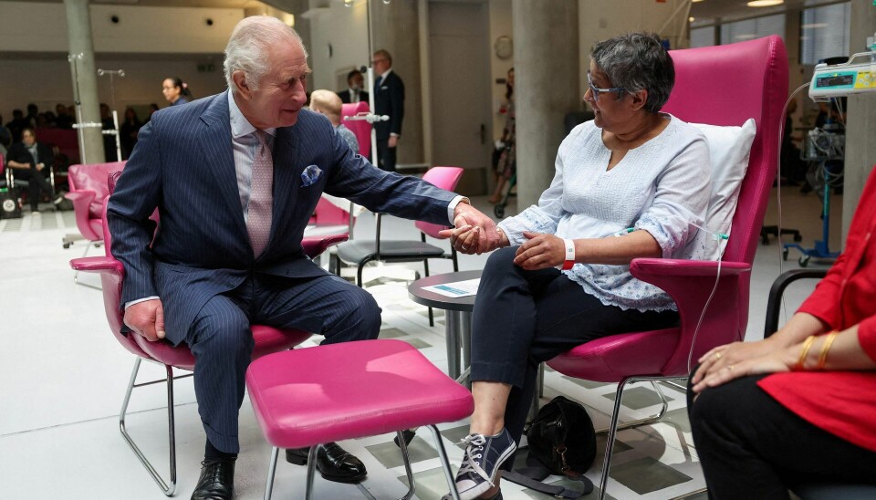 Kong Charles holder kræftpatient Asha Millan i hånden mens han indfølende lytter til hendes personlige beretning om kræft.