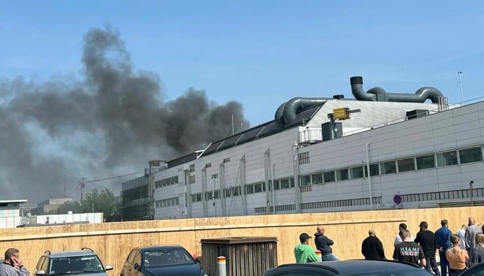 Sort røg fra branden vælter ud over den nærliggende motorvej.