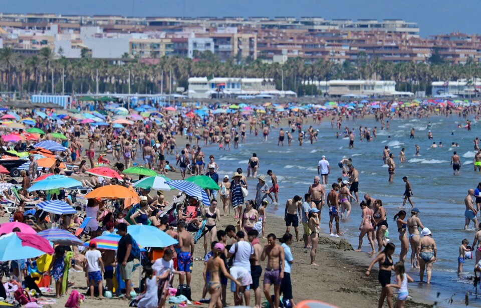 Tourists enjoy the beach in Valencia on July 5, 2024. (Photo by Jose Jordan / AFP)