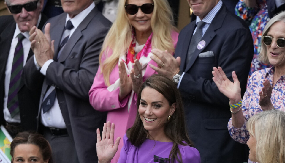 Kate vinker til publikum fra Royal Box, mens hendes søster Pippa Matthews til venstre ser på forud for herresinglefinalen ved Wimbledon.