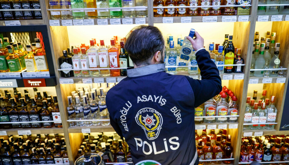 En tyrkisk politibetjent inspicerer flasker i en butik, der sælger alkohol, i Istanbul i midten af januar. Myndighederne rykkede ud på et tidspunkt, hvor 38 personer døde over fire dage i den tyrkiske storby efter at have drukket ulovligt fremstillet alkohol.