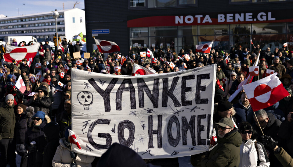 Demonstranter var lørdag mødt op ved USA's konsulat i Nuuk. Her havde mange medbragt flag og bannere.