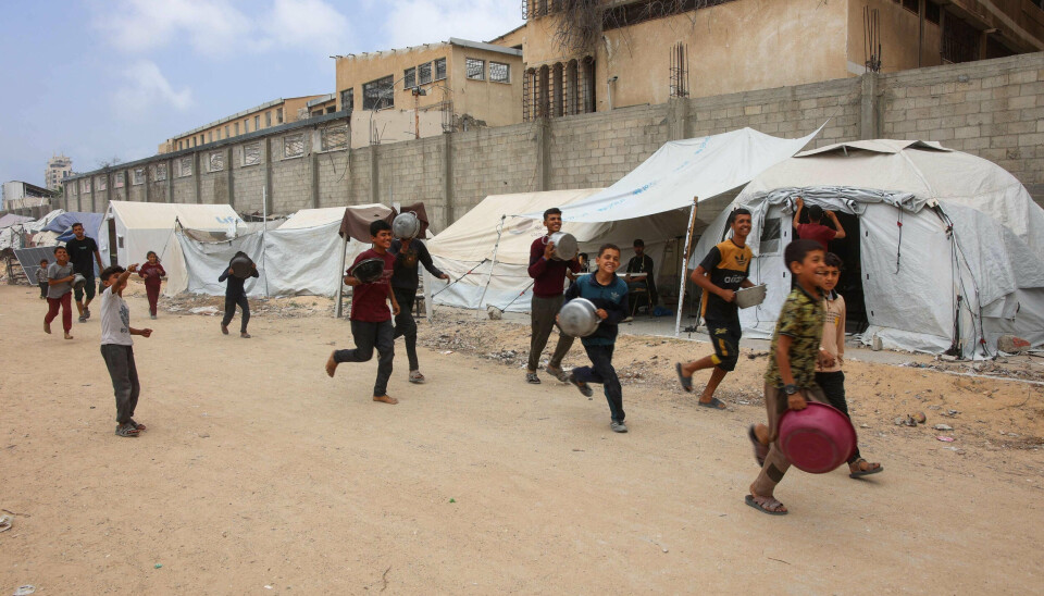 Palæstinensiske drenge løber mod en maduddelingen i Gaza By den 12. maj.
Siden marts har Israel fastholdt en hård blokade på Gaza.