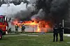 Brandmænd slukker kraftig brand i hus med flammer og sort røg