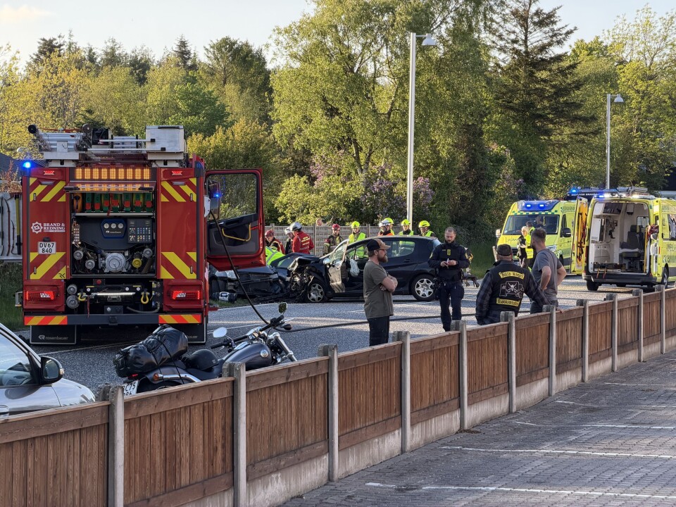 Udrykningskøretøjer og redningspersonale ved et færdselsuheld med en motorcykel på vejen.
