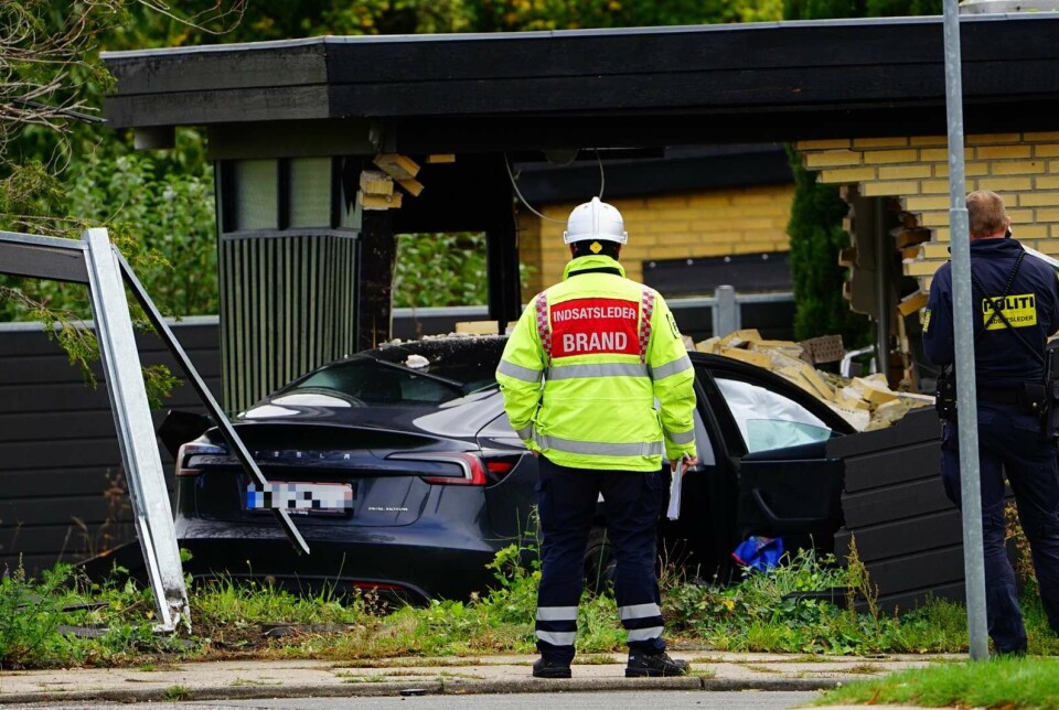 Beredskabsmedarbejder i refleksuniform ved en bolig med bil og stige.