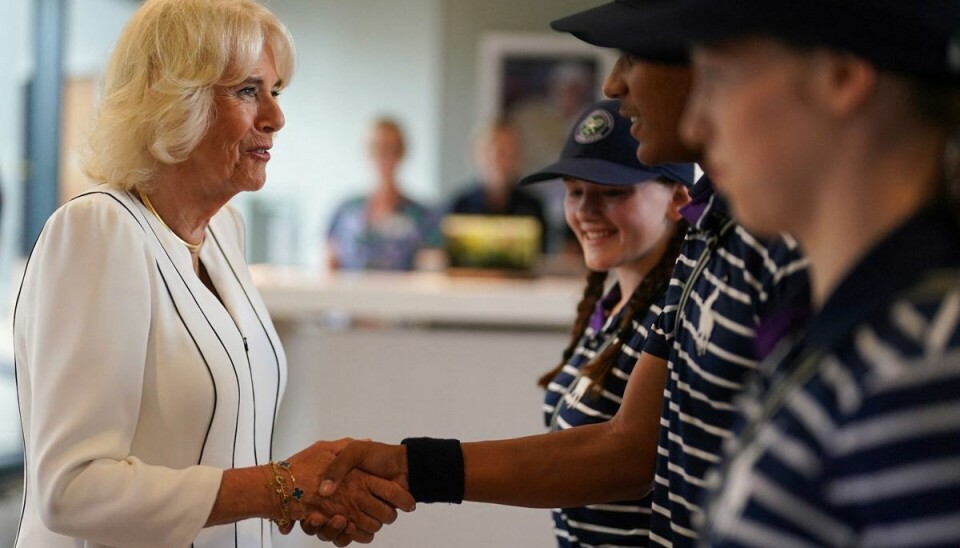 Dronning Camilla ses her sludre med to bolddrenge og en boldpige under sit besøg ved Wibledon-turneringen onsdag. Dronning Camilla ses her sludre med to bolddrenge og en boldpige under sit besøg ved Wibledon-turneringen onsdag.