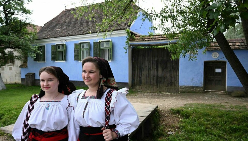 To piger i traditionelle folkedragter ses her foran kong Charles' hus i Viscri.