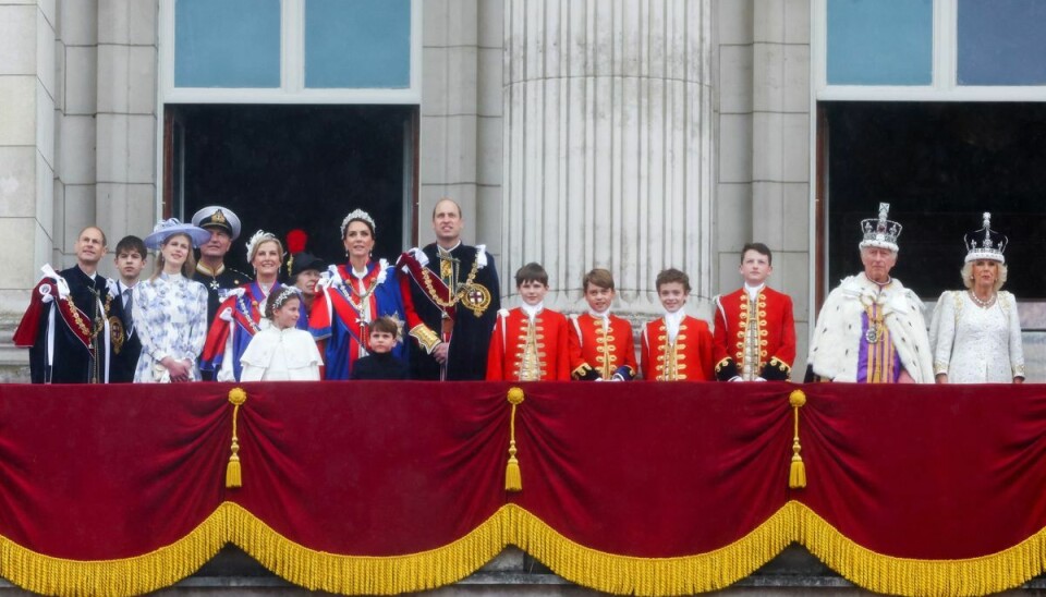 Den britiske kongefamilie på balkonen på Buckingham Palace. Kong Charles og dronning Camilla står til højre i billedet, mens prins William, Catherine og deres tre børn Charlotte, Louis og George er med. Det samme er Sophie, hertuginde af Edinburgh, prinsesse Anne og andre medlemmer af kongefamilien. Men ikke prins Harry og prins Andrew.
