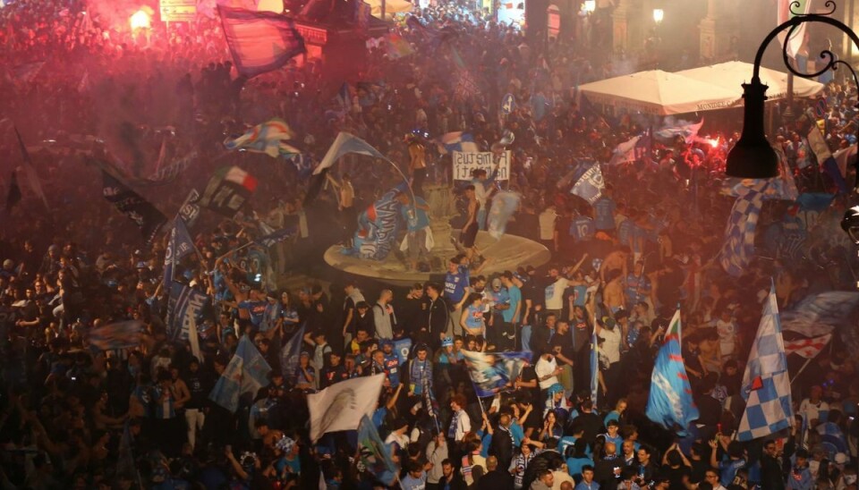 Fans i Napoli fejrer byens første fodboldmesterskab i 33 år. En person har mistet livet i forbindelse med fejringen. Fans i Napoli fejrer byens første fodboldmesterskab i 33 år. En person har mistet livet i forbindelse med fejringen.