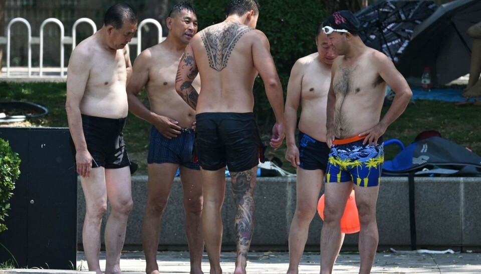 Mænd svømmer i en kanal i Beijing, mens Kina er truet af voldsomme varmegrader. Mænd svømmer i en kanal i Beijing, mens Kina er truet af voldsomme varmegrader.