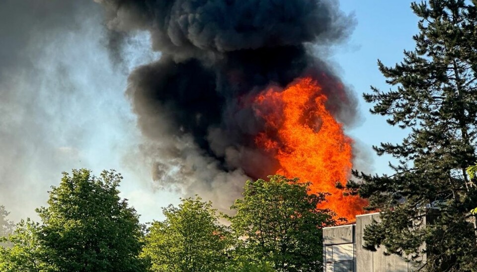 Store flammer står op gennem taget på den nedlagte skole.