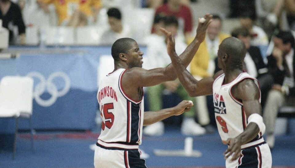 Magic Johnson og Michael Jordan (til højre) jubler i forbindelse med USA's første kamp ved OL i 1992 mod Angola. En trøje fra semifinalen mod Litauen er torsdag blevet solgt for 20 millioner kroner.
