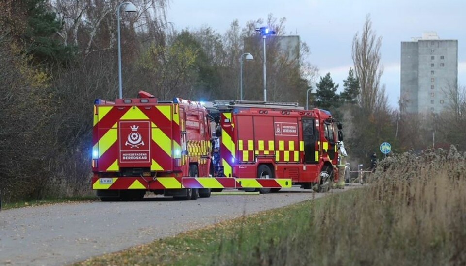 Politiet har afspærret ind ind til den udbrændte bil, der er gemt bag brandbilerne.