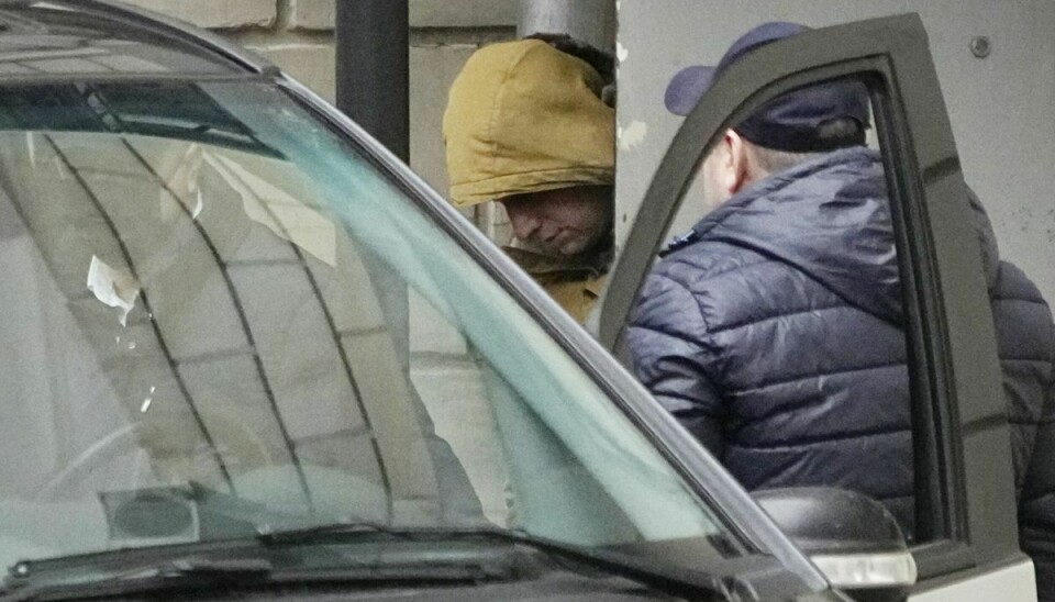 Med en gul hætte over hovedet bliver Wall Street Journals Moskva-korrespondent, Evan Gershkovich, eskorteret ind i en politibil efter et retsmøde i Moskva torsdag 30. marts. Nu har russiske myndigheder sigtet ham for spionage.