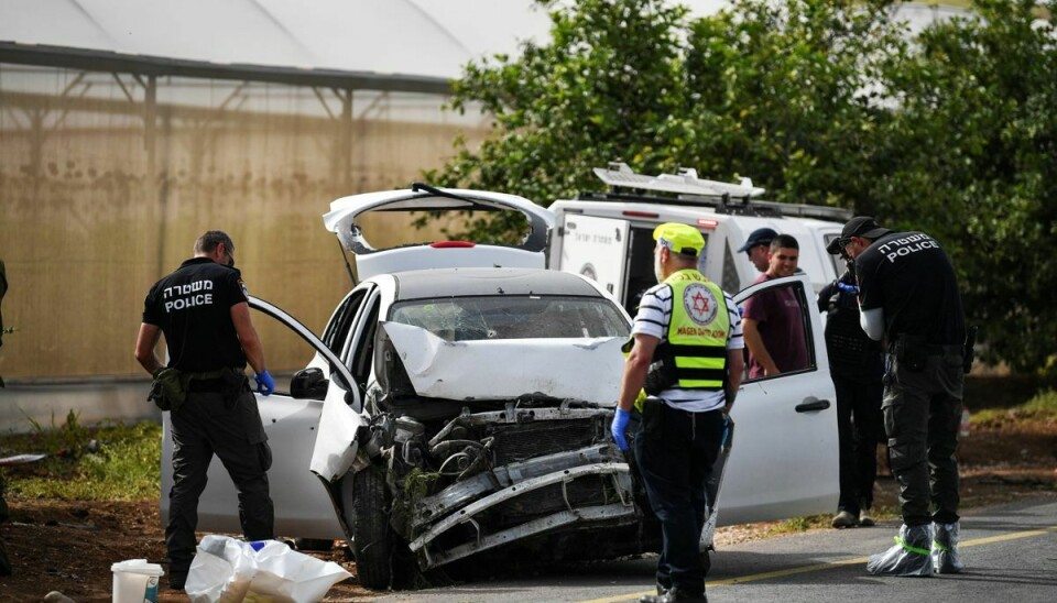 Israelske læger og politifolk tjekker en beskadiget bil på stedet for et skudangreb i Jordandalen på den israelsk besatte Vestbred den 7. april 2023.