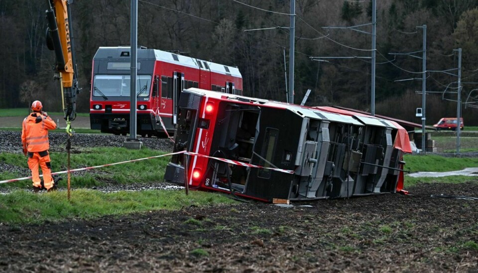 A train staff member works on the site of a train derailment near lakeside town of Luscherz, northwest of the capital Bernin on March 31, 2023. - Several people have been hurt in two separate train derailments that happened in quick succession in bad weather in northwestern Switzerland, police said The incidents took place about 30 kilometres apart, north of the Swiss capital Bern. (Photo by Fabrice COFFRINI / AFP)