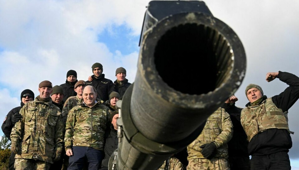 Den britiske forsvarsminister Ben Wallace, poserer sammen med ukrainske soldater ved en britisk Challenger 2 kampvogn. Rusland har rettet skarp kritik mod Storbritannien, som det beskylder for at have planer om at sende ammunition med forarmet uran til kampvognene i Ukraine.
