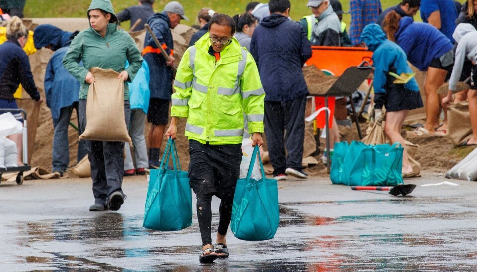 Folk løber i pendulfart til lagrene med sand for at fylde sækkene op for at beskytte deres ejendele. Folk løber i pendulfart til lagrene med sand for at fylde sækkene op for at beskytte deres ejendele.