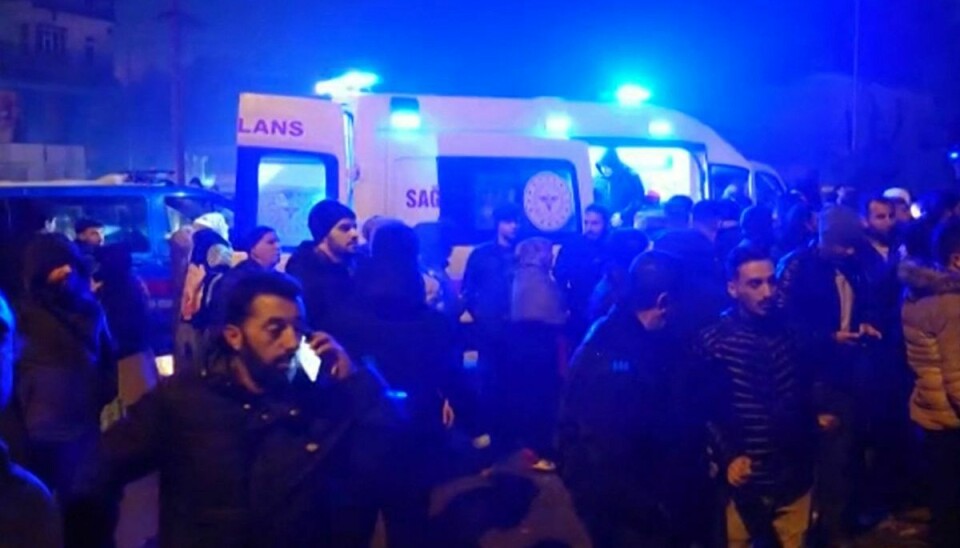 Folk står nær en ambulance, mens der en redningsindsats er i gang, efter at et jordskælv ramte blandt andet Diyarbakir i det sydlige Tyrkiet.