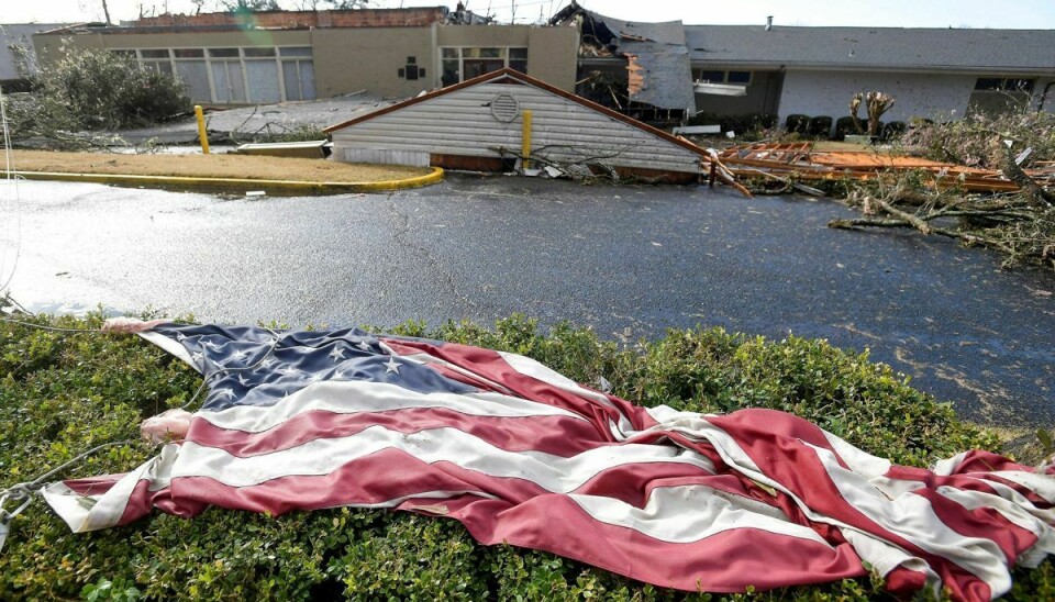 Et amerikansk flag ligger ikke langt fra ødelagte bygninger i Alabama efter et slemt uvejr torsdag.