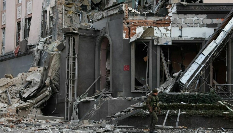 En person fra militæret i Ukraine går ved en bygning i Kyiv, der er blevet smadret under et angreb nytårsaftensdag 2022.