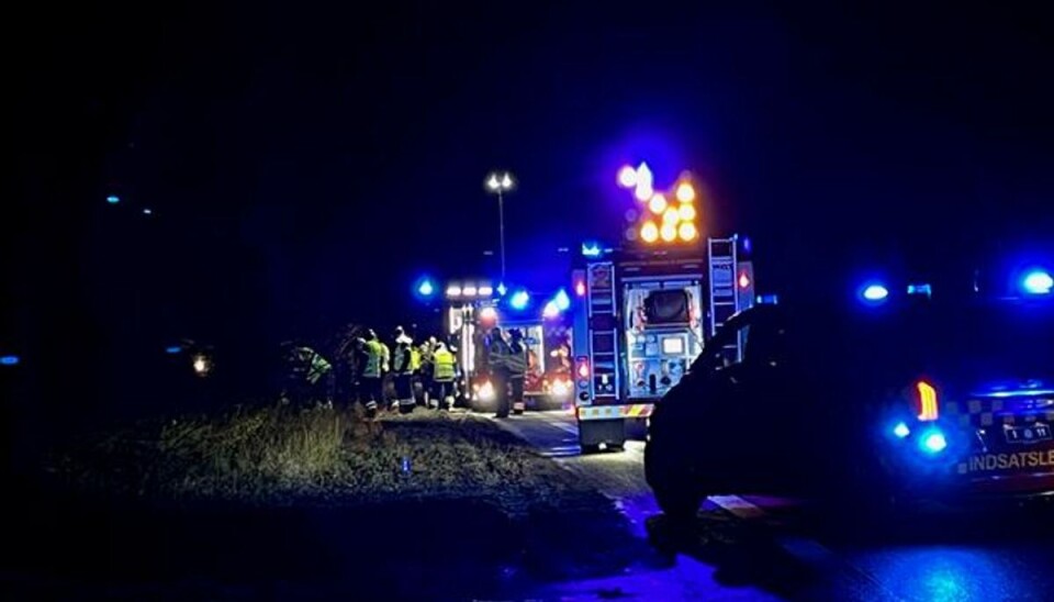 Det ligner en hel brandmandskonference, men de er blot ved at finde ud af, hvordan de tre forulykkede skal hjælpes ud af bilen.