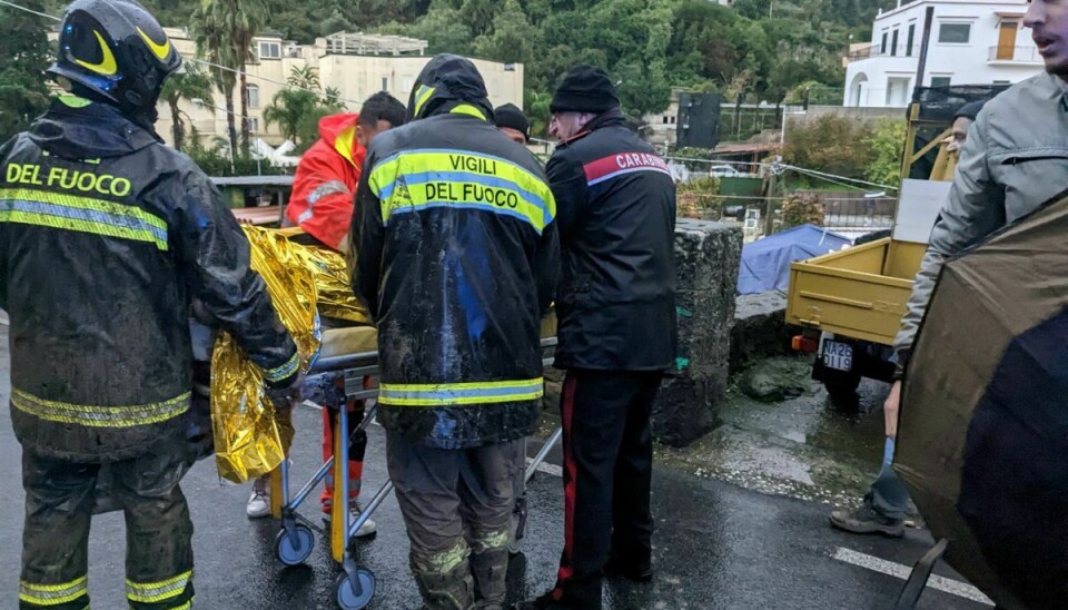 Reddere hjælper en såret person efter et jordskred på den italienske feriø Ischia.
