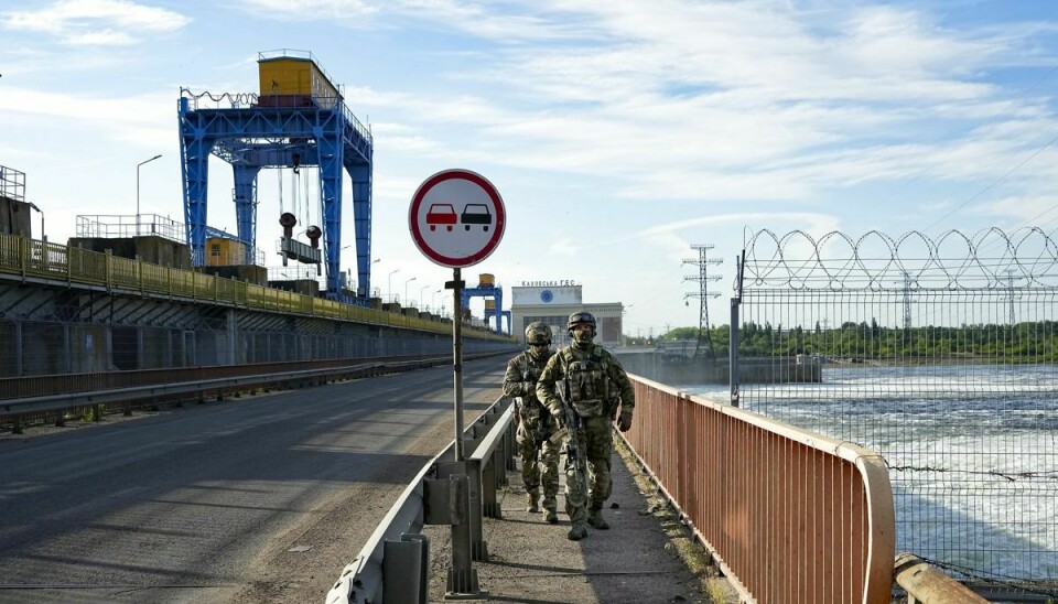 Russiske soldater ses patruljere kraftværket Kakhovka. Ukraine mener, at Rusland er ved at forberede en sprængning af dæmningen, der hører sammen med kraftværket, hvilket kan føre til voldsomme oversvømmelser langs Dnepr-floden. (Arkivfoto).