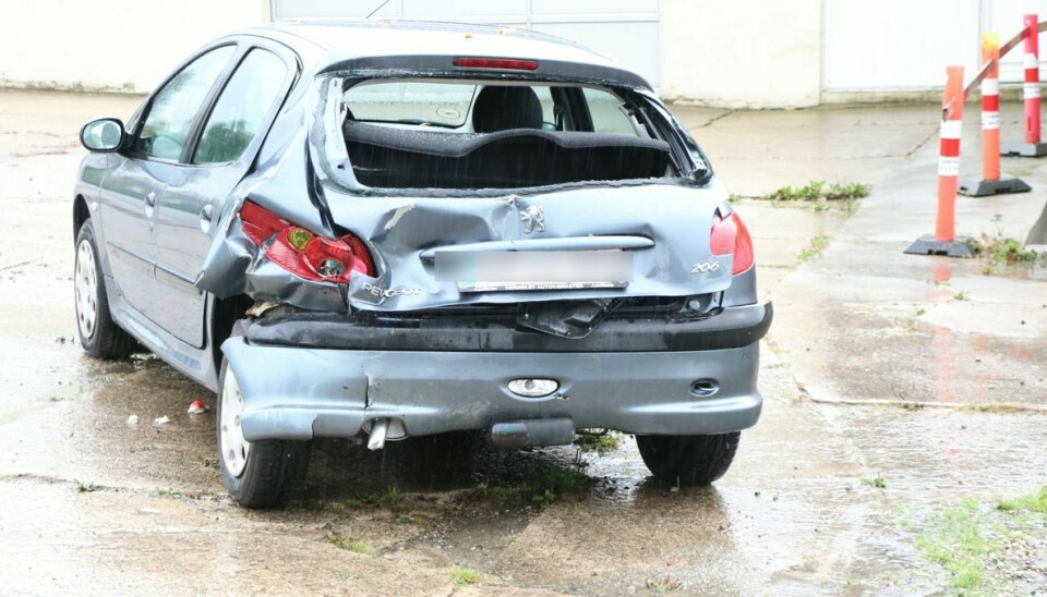 Peugeoten blev trykket ind og fik knust bagruden, da motorcyklisten ramte den.