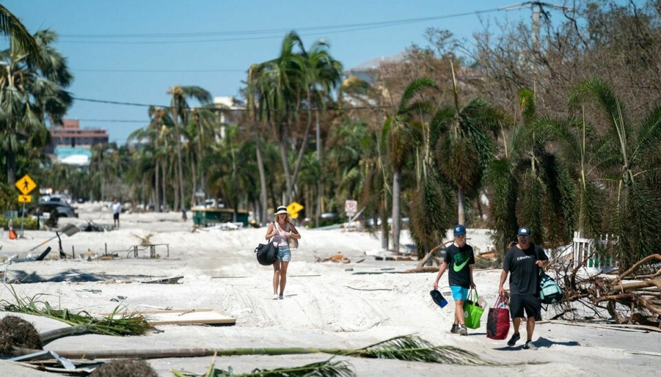 Flere husejere i Bonita Springs i Florida bærer deres ejendele ud af deres huse, efter at orkanen Ian har hærget deres nabolag.