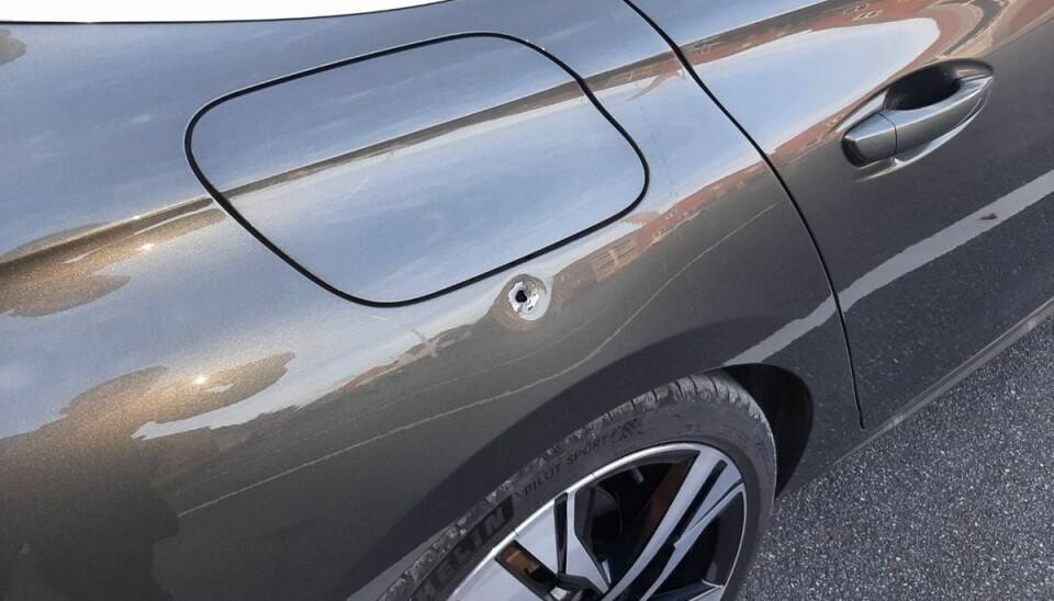 En vildfaren kugle har ramt bilen lige under benzindækslet. En vildfaren kugle har ramt bilen lige under benzindækslet.