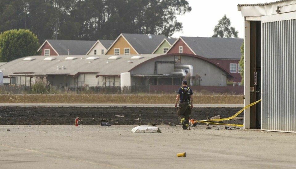 Vragrester fra det ene nedstyrtede fly ses her ved en flyhangar i Watsonville Municipal Airport.