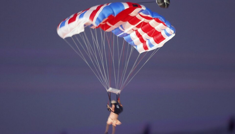 Gary Connery ses her som dronning Elizabeth på vej ned mod det Olýmpiske Stadion i 'Union Jack-faldskærm i 2012. Gary Connery ses her som dronning Elizabeth på vej ned mod det Olýmpiske Stadion i 'Union Jack-faldskærm i 2012.