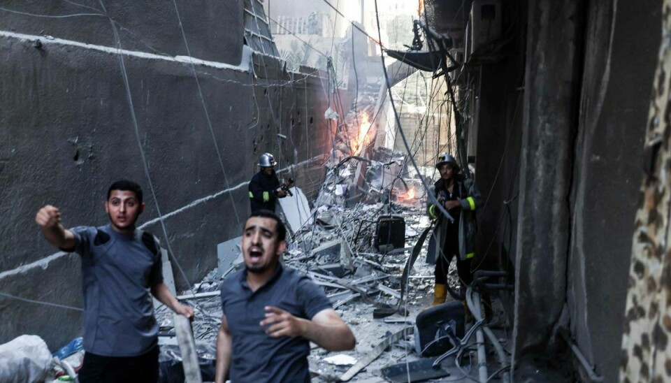 Brandfolk forsøger at nedkæmpe en brand, efter Israel fredag har angrebet en bygning i Gaza By. En militant islamistisk leder meldes dræbt.