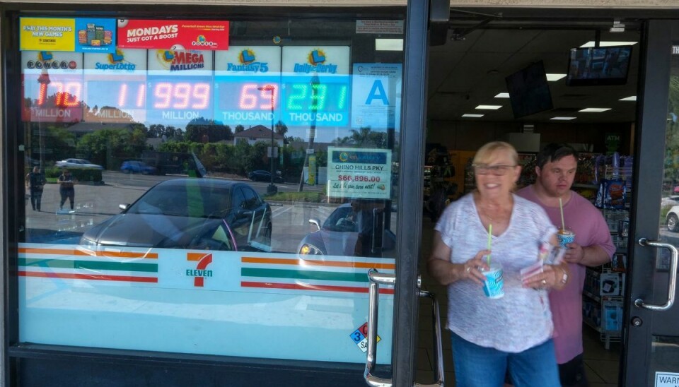 Kunder på vej ud af 7Eleven-butikken i Californien. Her er den kommende lottogevinst så stor, at selv det digitale skilt ikke længere kan være med, fordi gevinsten er har for mange cifre. 999 millioner står der. Præmiesummen er på 1 milliard dollars.