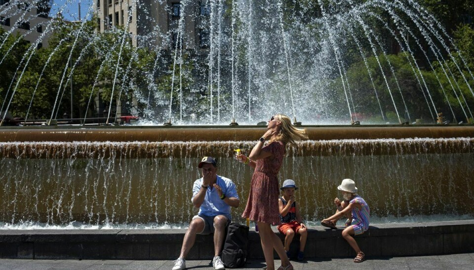 En familie køler ned ved et springvand i den spanske storby Barcelona, mens de påfører et ekstra lag solcreme. Den varme, der i noget tid har præget Sydeuropa, kommer nu også længere nordpå til blandt andet Tyskland og Storbritannien.