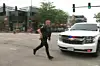 En politibetjent løber over en gade efter et skyderi ved en 4. juli parade ved Chicago-forstaden Highland Park, Illinois.